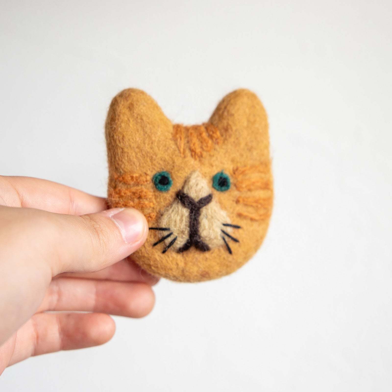 羊毛フェルト 猫 焦げ茶色、口鼻周り茶色の猫　ブローチ ハンドメイド フェアトレード 羊毛フェルト ネコ ブローチ ブラウン